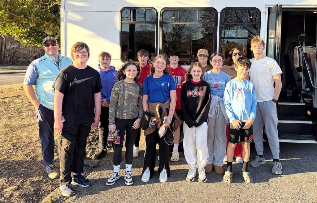 group of children standing in front of bus