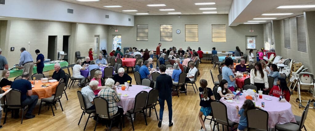 people in a room sitting around various tables